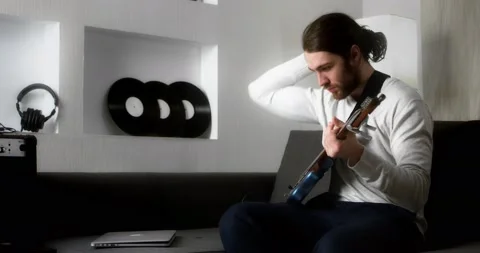 Young man is learning to play the guitar online. Stock Footage 169937395