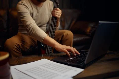 Young man learning playing guitar through internet Foto stock