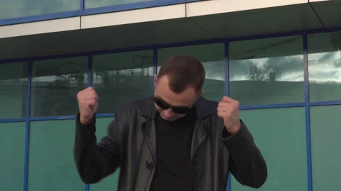 Young man in leather jacket and sunglasses standing outdoor and dancing Stock Footage 97889514