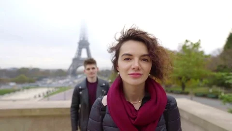 Young man in leather jacket slowly coming to girlfriend from behind outdoor Stock Footage 98895213