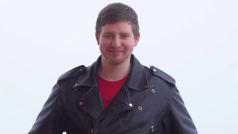 A young man in a leather jacket smiles Stock Footage 73531491