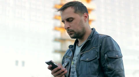 Young Man in Leather Jacket Talking On Mobile Phone In The City HD Stock Footage 37803787