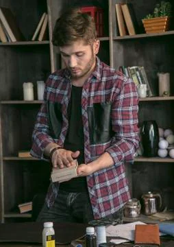 Young man leather maker packed in small cardboard box leather handmade wallet Stock Photos