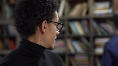 Young man in library in eyeglasses smiling joyful Stock Footage 121539391