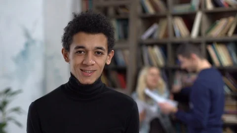 Young man in library smiling cheerful grimace Stock Footage 121646479