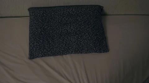 Young man lies down on the bed, takes off his glasses and turns off the lights 動画素材 98881680