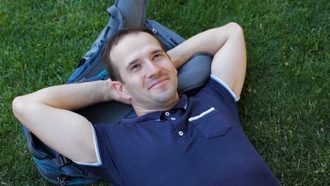 Young man lies on the grass Stock Footage 119253590