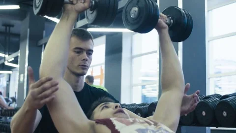 A young man is lifting dumbbells Video stock 77590019