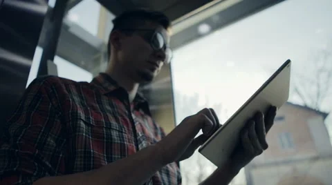 A young man lifting up by the elevator is becoming happy with his electronic Stock Footage 62026414