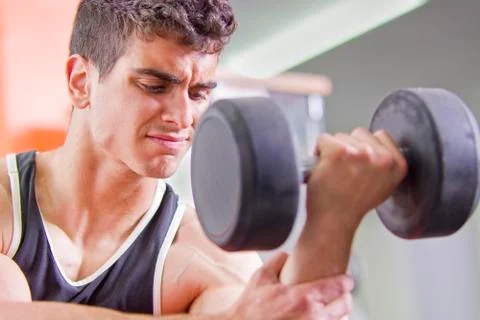 Young man lifting weights Stock Photos