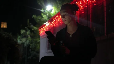 Young man lighted of red light drinks water outdoors at night 2 動画素材 95861560