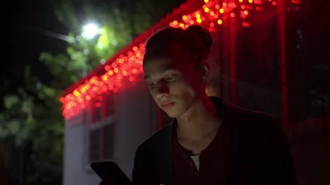 Young man lighted of red light drinks water outdoors at night Vidéo 95861778