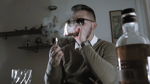Young Man Lighting A Cigar End Enjoying His End Of The Day by A Glass Of Whiskey Stock Footage 94031138