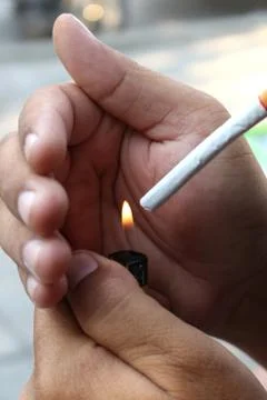Young man lighting cigarette Stock Photos