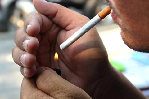 Young man lighting cigarette Stock Photos