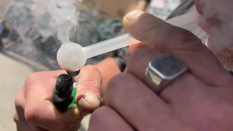 A young man lights up a marijuana joint and smokes it. Stock Footage 247130428