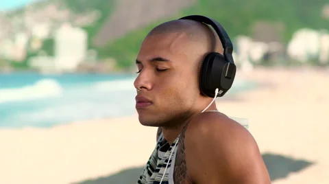Young man listening to music on beach Stock-Footage 59375079