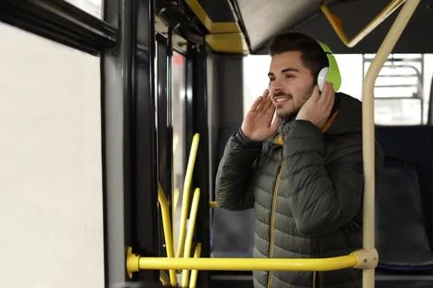 Young man listening to music with headphones in public transport Stock Photos