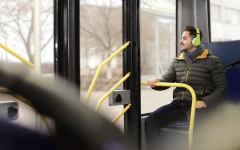 Young man listening to music with headphones in public transport Stock Photos