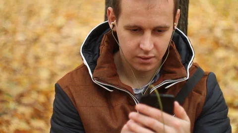 Young man listening to music on smartphone Stock Footage 68737553