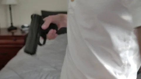 A young man loading a handgun pistol 스톡 동영상 75484644