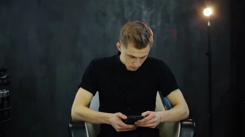 Young man in loft studio uses smartphone and prepares for video interview Stock Footage 131548630