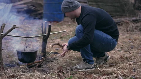 Young man looking around the campfire Stock Footage 234539932