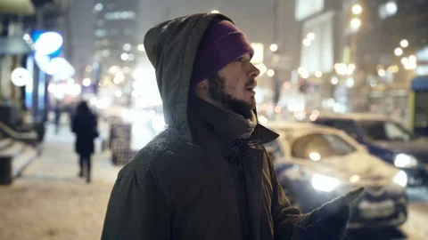 Young man looking around to order a Taxi Cab using Smartphone App Stock Footage 94995318