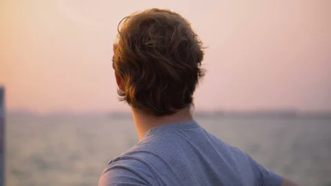 Young Man Looking at Beautiful Sunset Over Ocean - Success and Achievement Video stock 126259299
