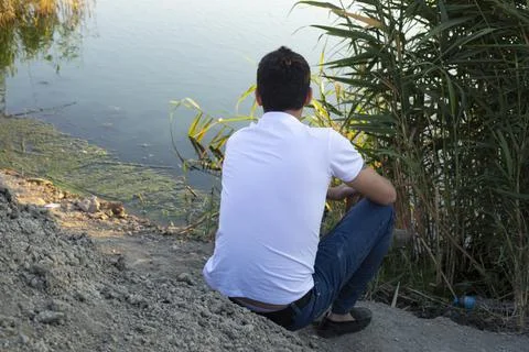The young man looking at the beautiful view at the lake Stock Photos