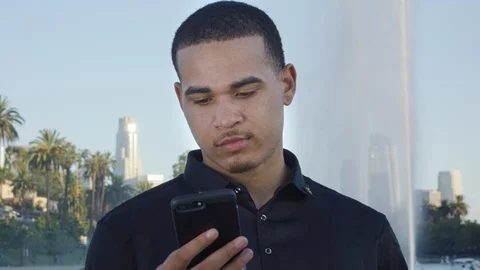 Young man looking bored as he reads something on his cellphone Stock Footage 119335625