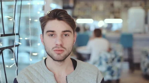 Young man looking at the camera and drink coffee in cafe Stock Footage 58818075