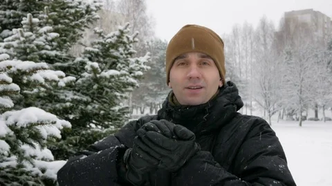 A young man looking at the camera and playing with snow in winter forest. It Stock Footage 71215391