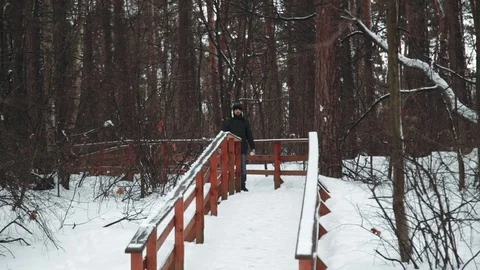 A young man looking at the camera and playing with snow in winter forest. It Stock Footage 73669377