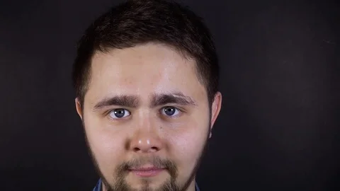 A young man is looking at the camera and smiling. Close-up face shot. Stock Footage 106350737