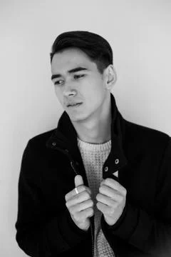 Young man looking at camera and holding the coat lapels.Model posing Stock Photos