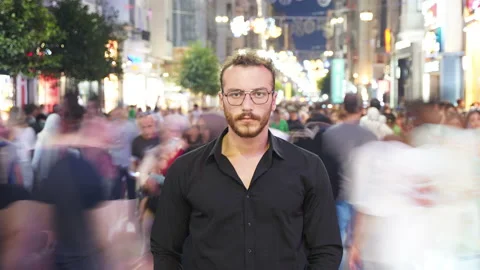 Young man looking at camera in crowd. Timelapse video. 库存影片 213532575
