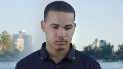Young man looking at camera in front of park in Los Angeles Stock Footage 119336287
