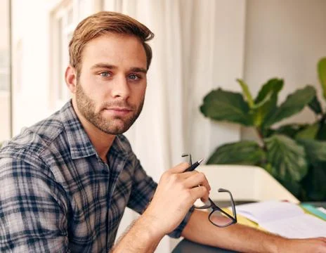 Young man looking at camera holding glasses Stock Photos