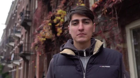 Young man looking at camera. Portrait of a happy handsome young man in a urban Stockbeeldmateriaal 70053310