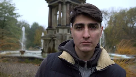 Young man looking at camera. Portrait of a happy handsome young man in a urban Stock-Footage 70075868