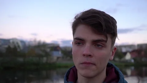 Young man looking at camera. Portrait of a serious handsome young man in a park Stock-Footage 70818438