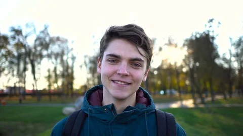 Young man looking at camera. Portrait of a happy handsome young man in a park Stock-Footage 70902569