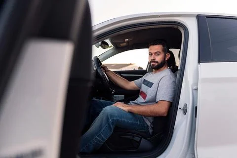Young man looking at camera sitting in his car Stock Photos