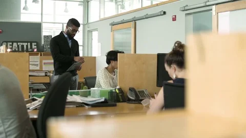 Young man looking at camera while working in an office Stock Footage 77093822