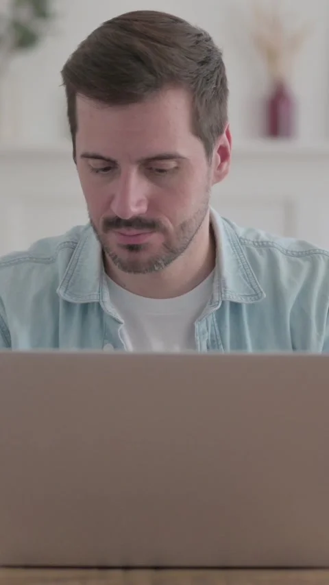 Young Man Looking at Camera while using Laptop, Vertical Video Video stock 328969098