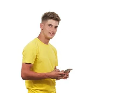 A young man looking at camera while holding phone on white background Foto stock