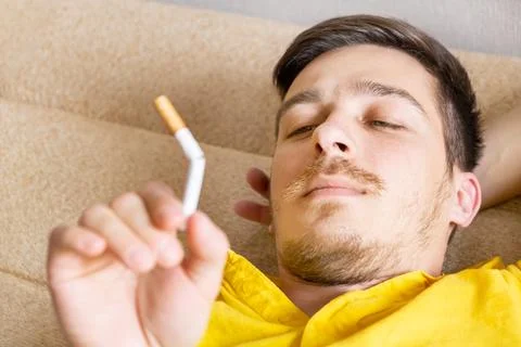 Young Man looking at a Cigarette Foto stock