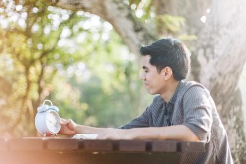 Young man looking at clock while studying Stock Photos