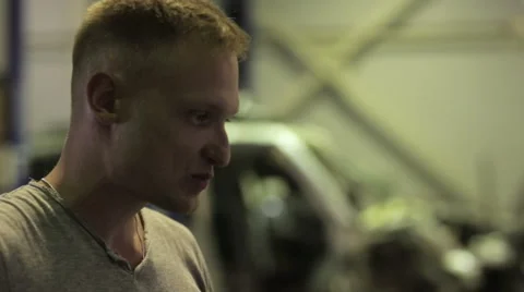 Young man looking at the computer reading condition his car Stock Footage 67949330